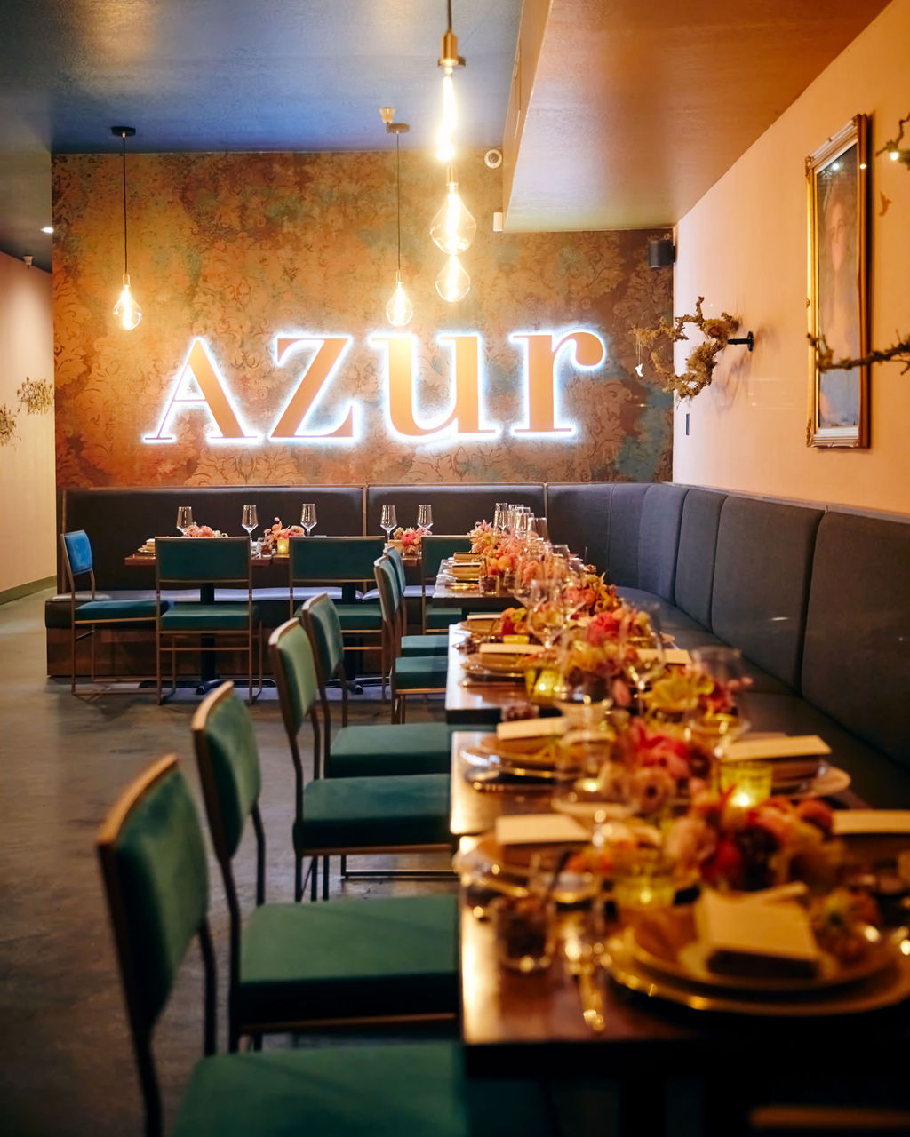 A table set with flowers and wineglasses inside Azur Wine Lounge.